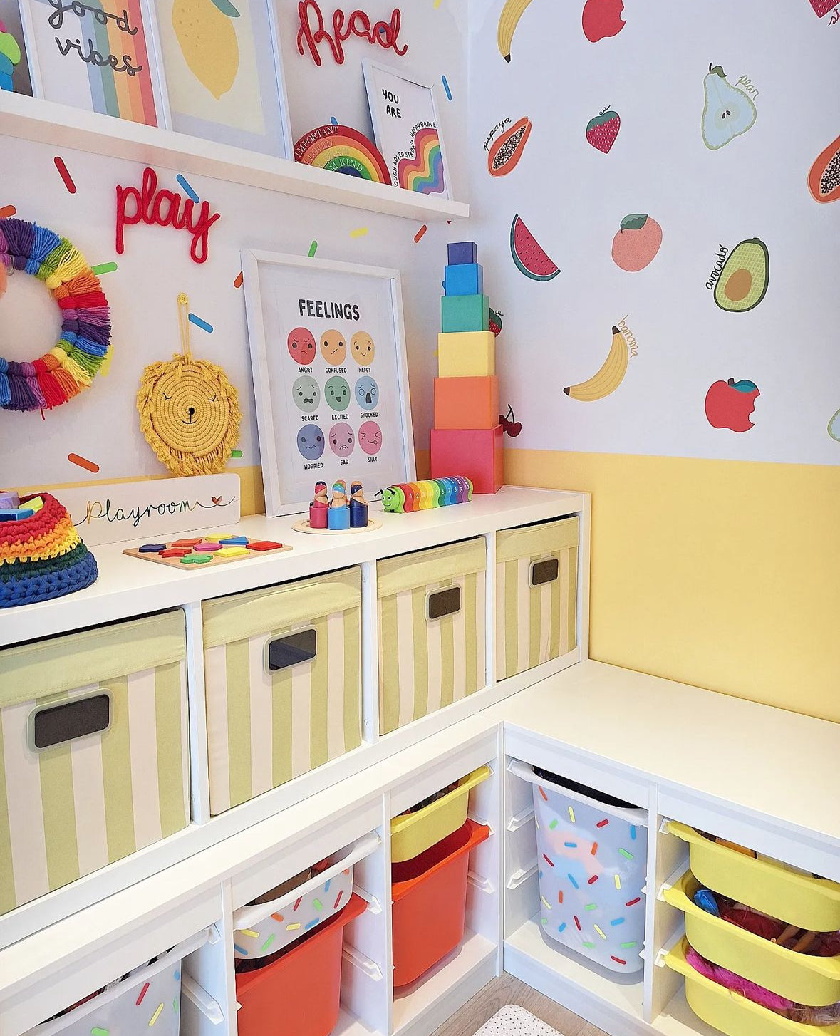 Children's playroom with colourful bins and wall fruit decals.