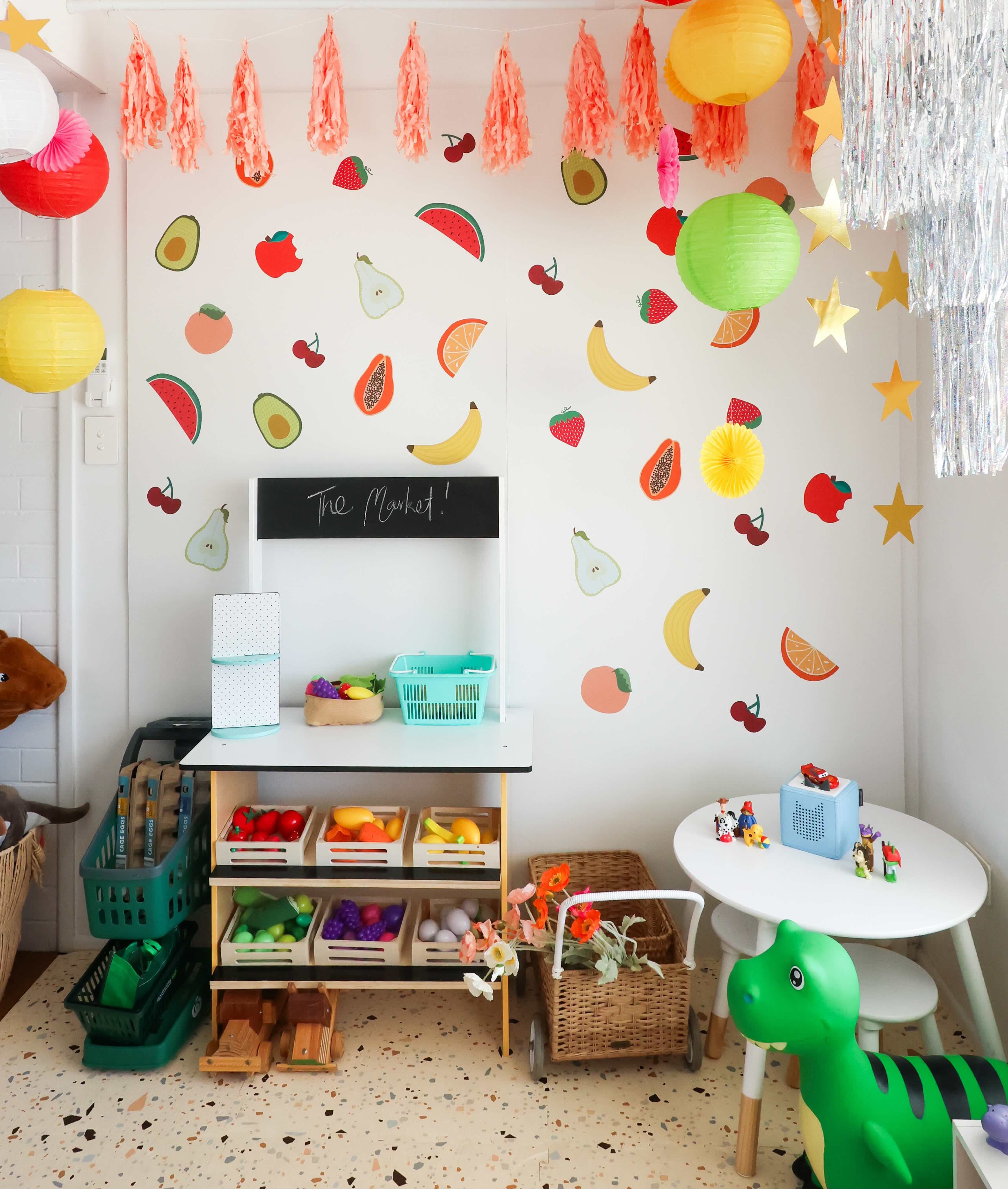 Children's playroom with colorful fruit decals and educational toys.