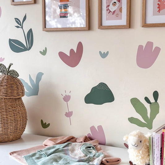 Children's room with decorative wall stickers, a wicker basket, and soft toys.